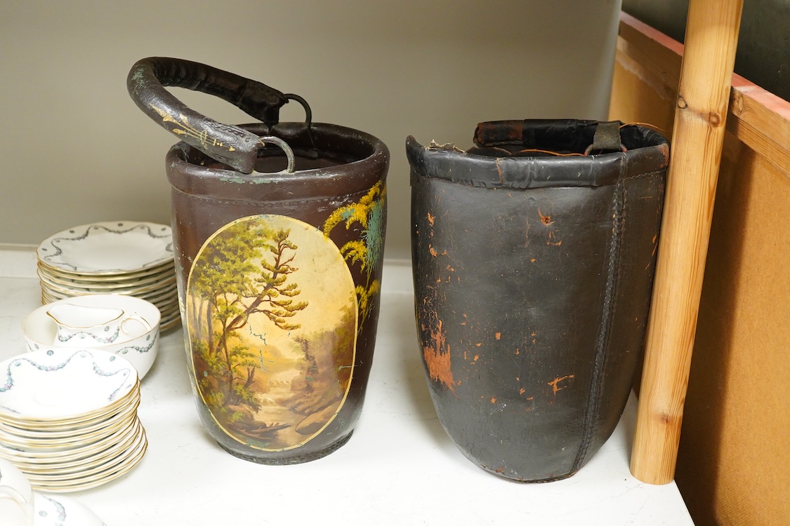 Two leather shot buckets, one with landscape cartouche, the other an advertising cartouche, 30cm high